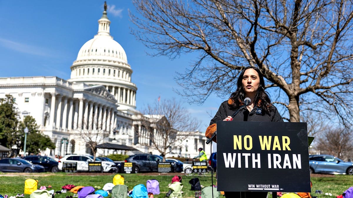 Rep. Yassamin Ansari speaking on Capitol Grounds in front of a shoe memorial.