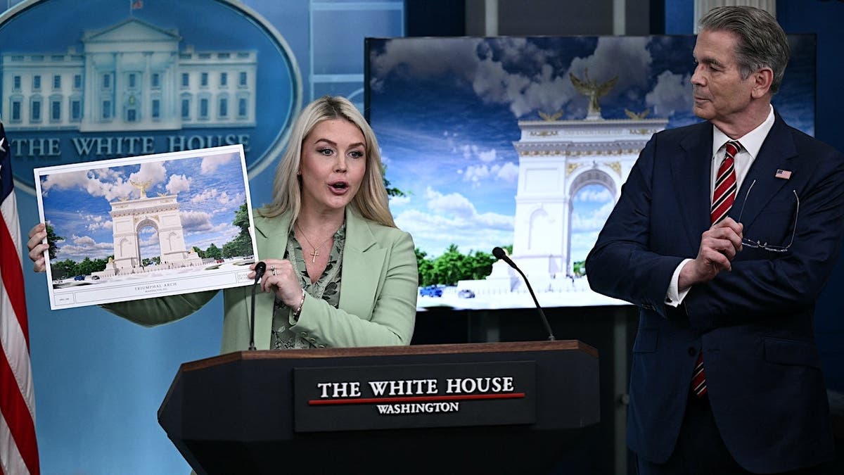 US Secretary of Treasury Scott Bessent looking on as White House Press Secretary Karoline Leavitt shows an artist's rendition of President Donald Trump's planned Triumphal Arch