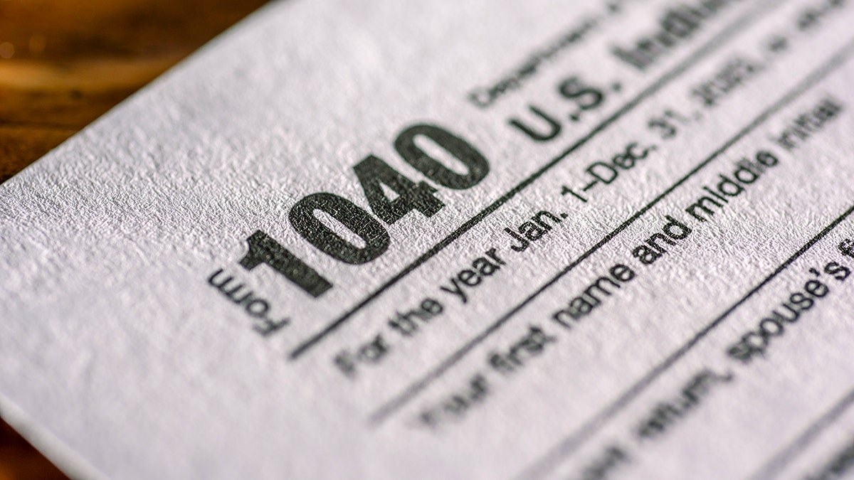 1040 tax form on a table with a warning about fake refund issue messages