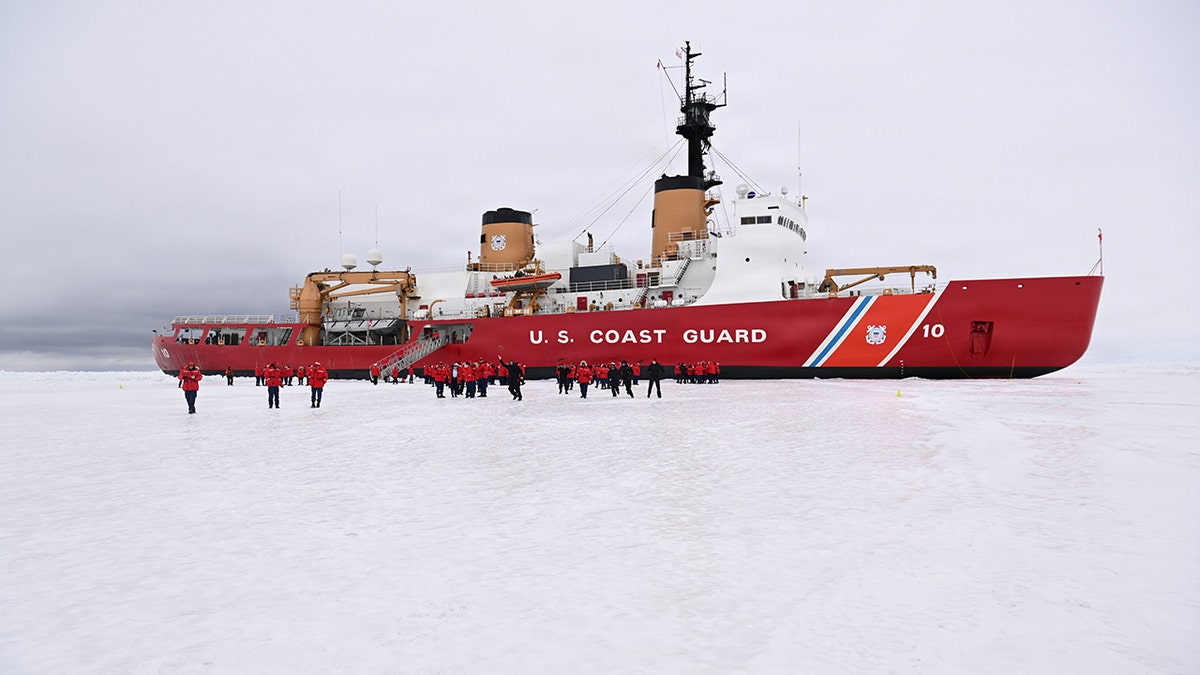 USCGC Polar Star icebreaker sitting hove-to in the Ross Sea with crew members on deck