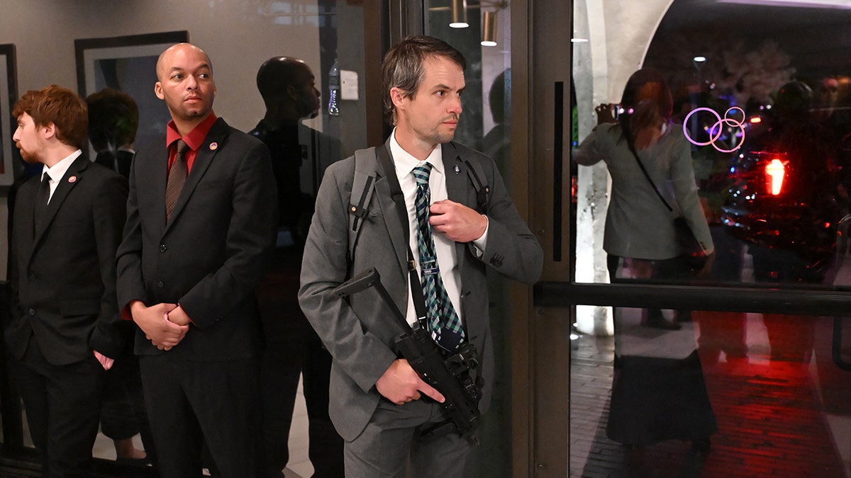 Secret Service agent holding a weapon standing in the Washington Hilton lobby