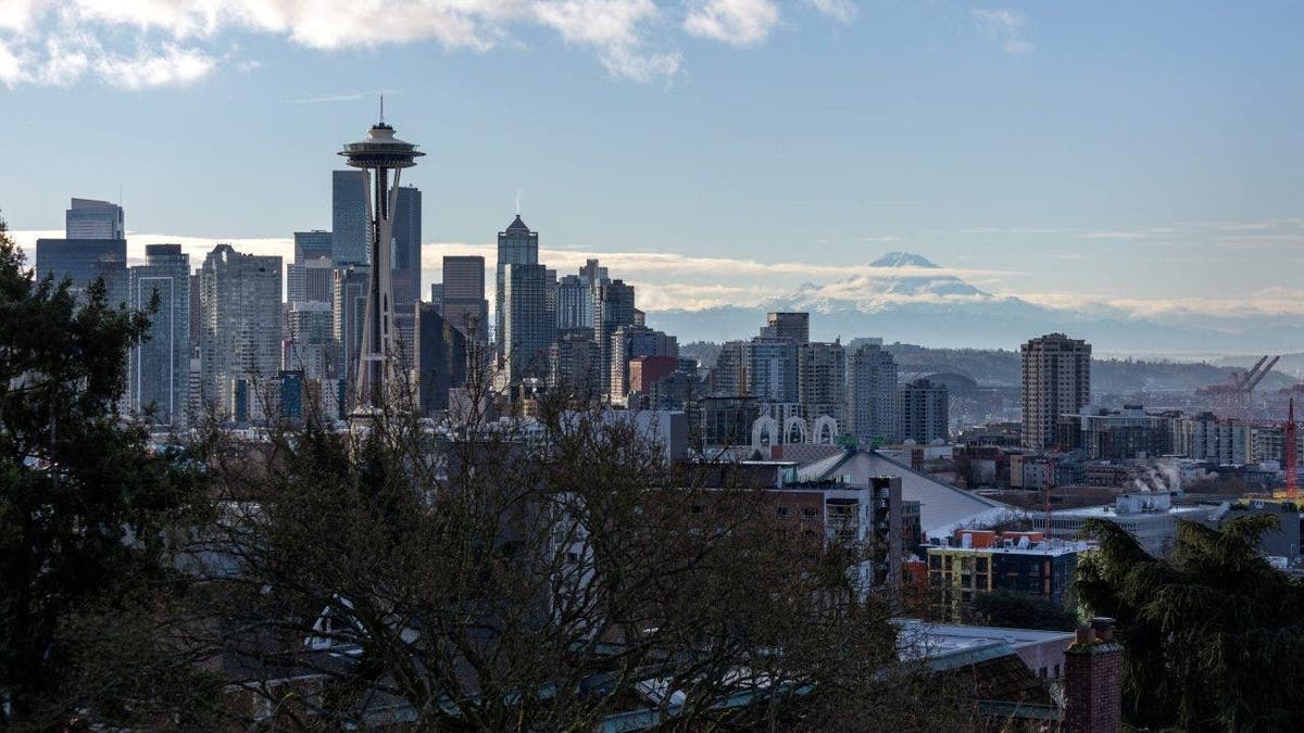The Space Needle standing over the Seattle skyline with Mt. Rainier in the background.