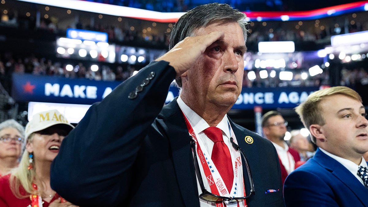 Rep. Barry Moore saluting during the National Anthem at Fiserv Forum