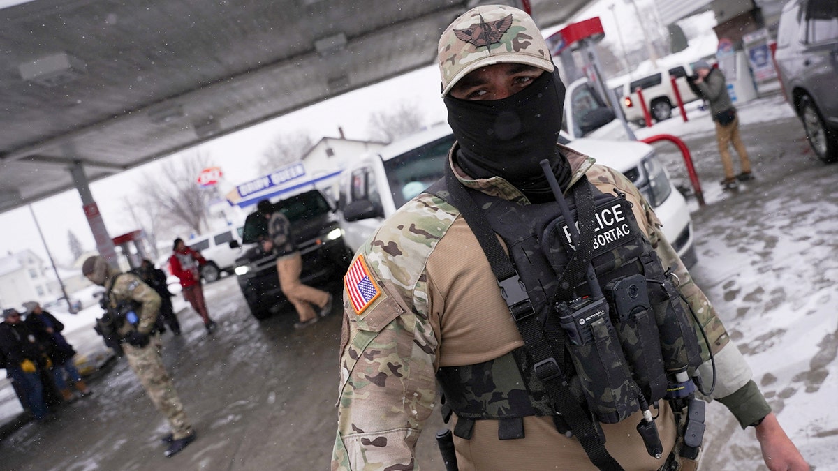A federal agent from commander Greg Bovino's team standing at a gas station
