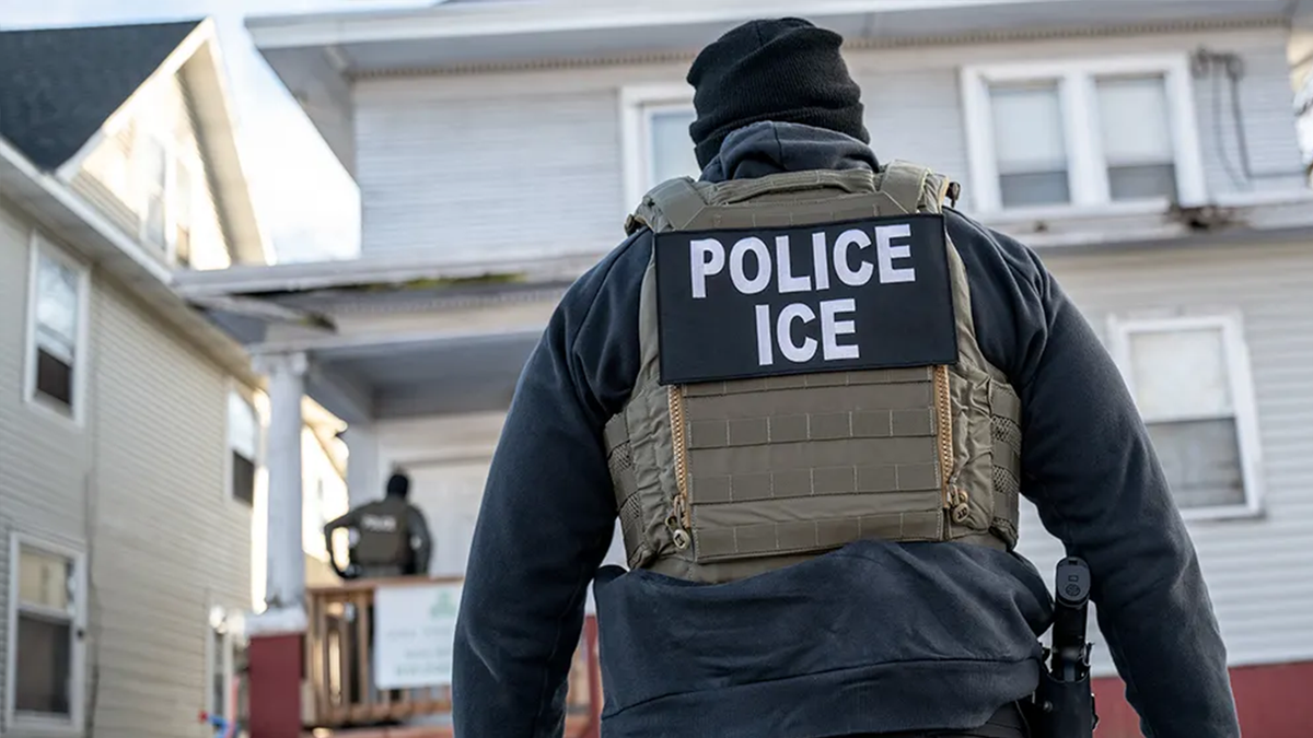 Federal law enforcement agent standing outside a home during a raid in south Minneapolis