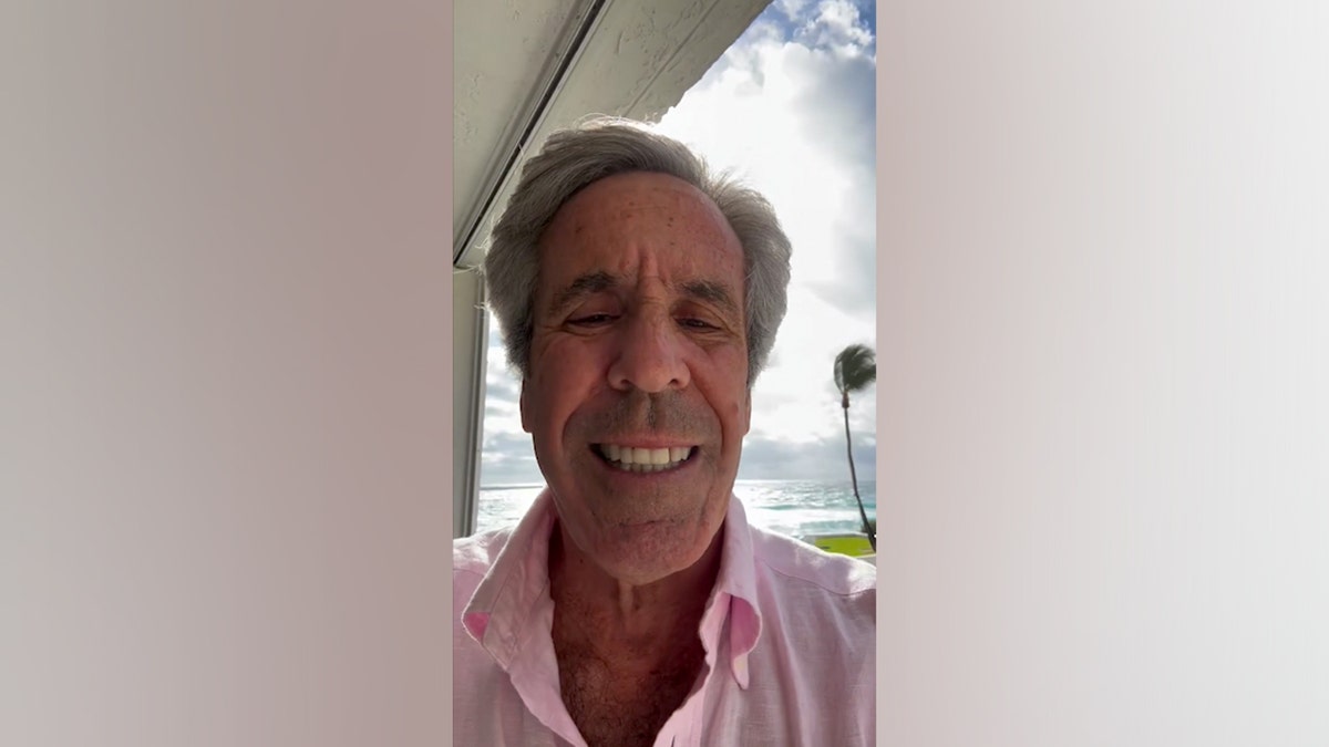 Jeffrey Epstein look-alike Palm Beach Pete standing in front of a beachfront view wearing a linen shirt