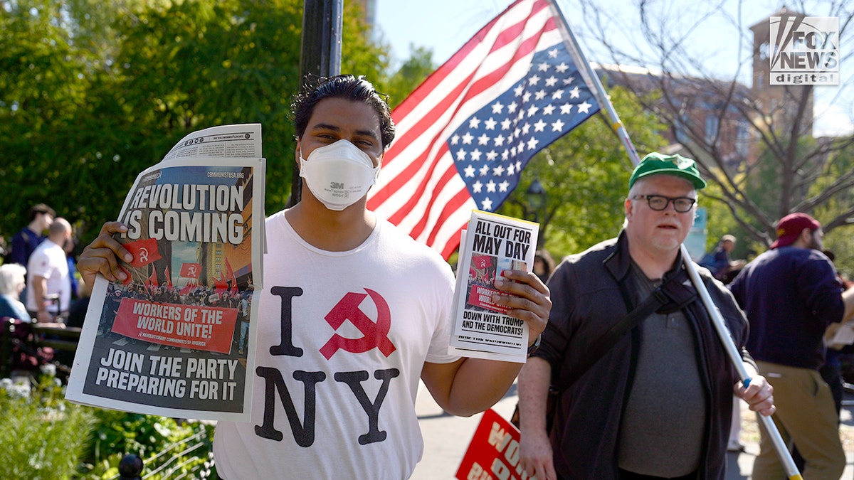 Supporters of Communism hold up flyers and a newspaper during the May Day march in New York City, N.Y., Friday, May 1, 2026.