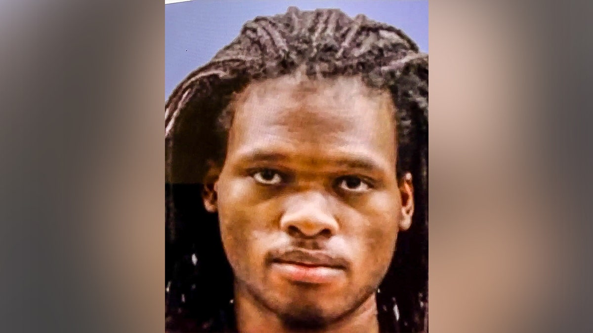 Nasire Best holding a revolver in a headshot photo.
