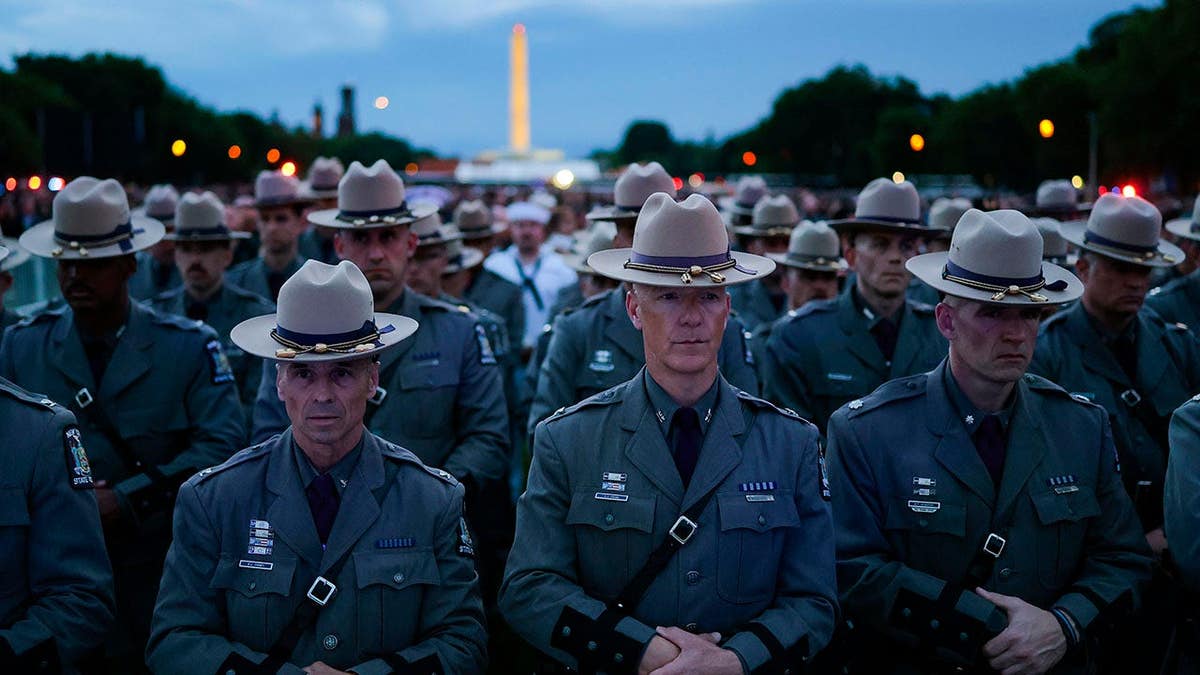 Law enforcement officers standing on the National Mall during a candlelight vigil