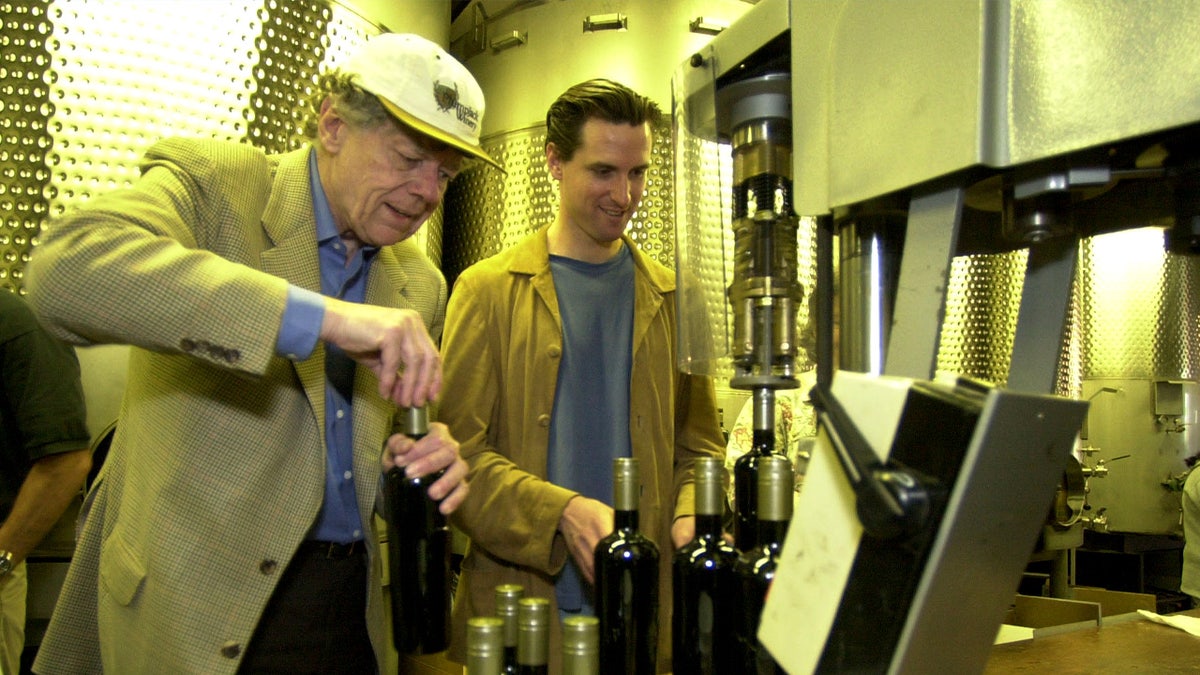 Gordon Getty and Gavin Newsom sealing wine bottles with screwcaps at Plumpjack winery.