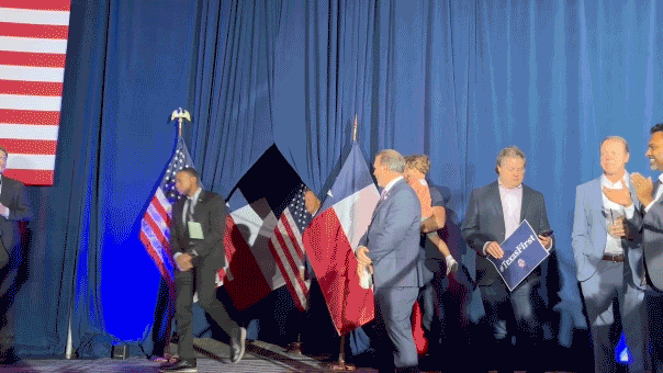 Ken Paxton waving while entering stage
