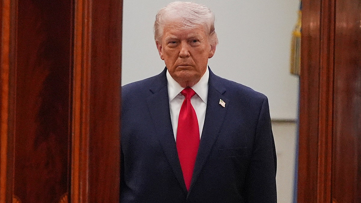 President Donald Trump standing in the Cross Hall of the White House speaking