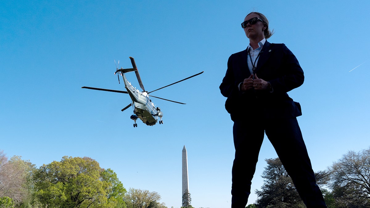 U.S. Secret Service Special Agent standing guard as Marine One lifts off with President Donald Trump aboard