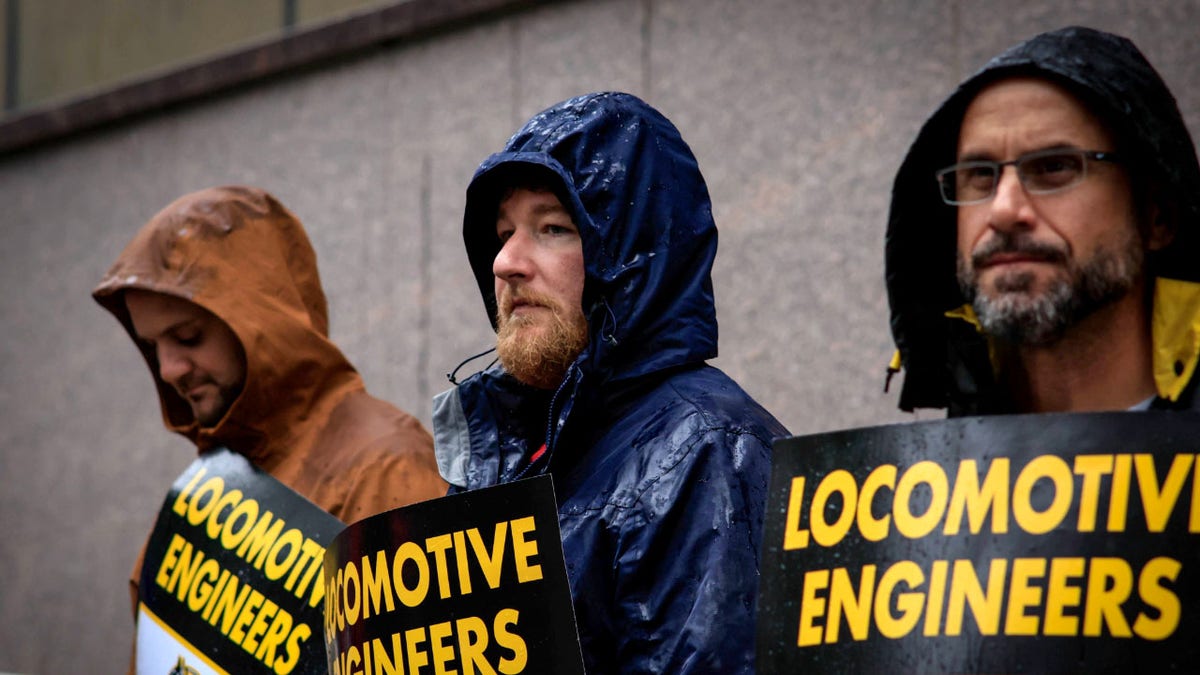 Members of Brotherhood of Locomotive Engineers and Trainmen holding posters during strike outside NJ Transit headquarters in Newark