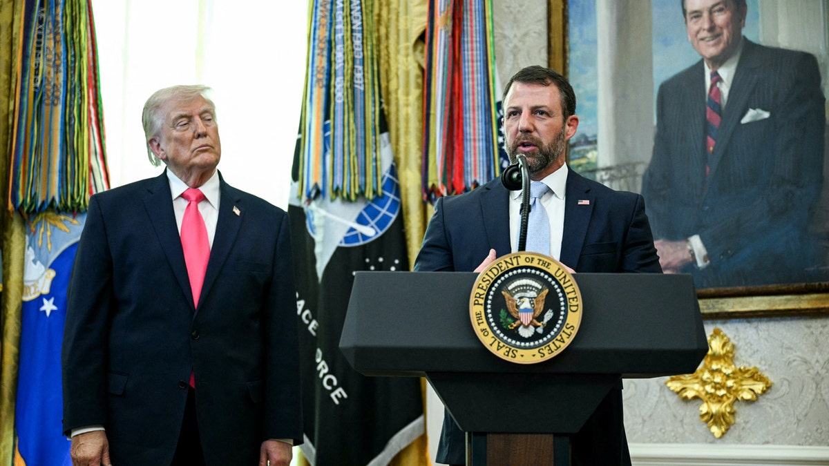 President Donald Trump looking on as Secretary of Homeland Security Markwayne Mullin speaks in the Oval Office