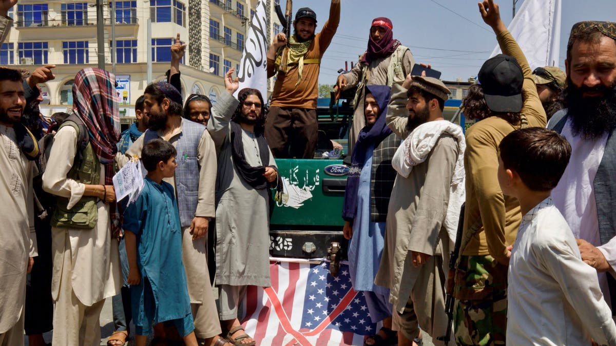 Members of the Taliban standing on a U.S. flag during a rally in Kabul