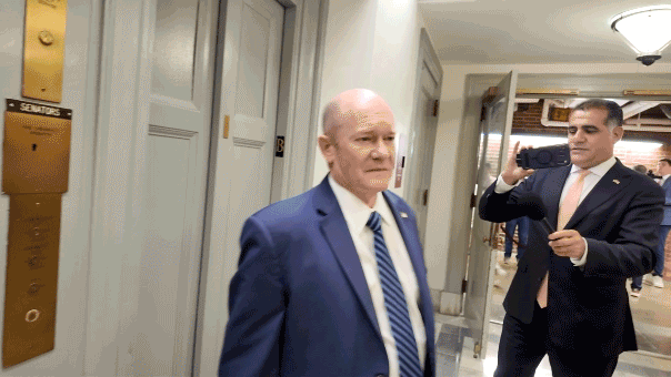 GIF of Chris Coons shaking his hand and head at reporters