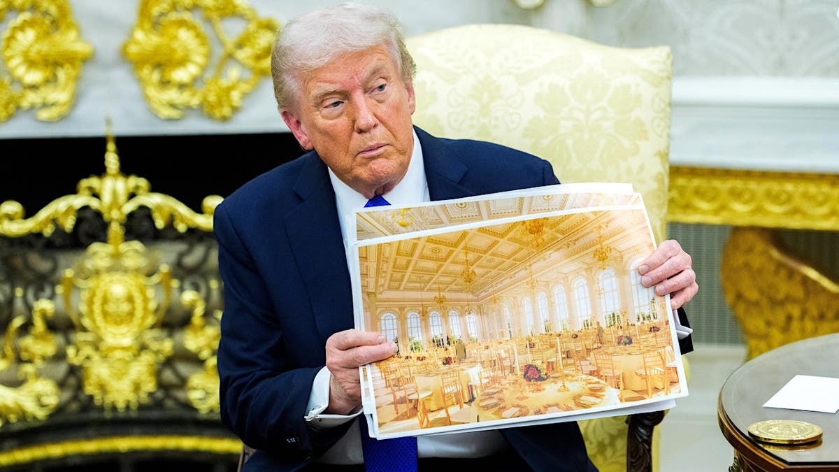 President Donald Trump holding a design rendering of a proposed presidential ballroom at the White House.