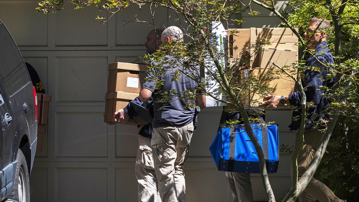 FBI agents carrying boxes outside John Bolton's house in Bethesda, Maryland