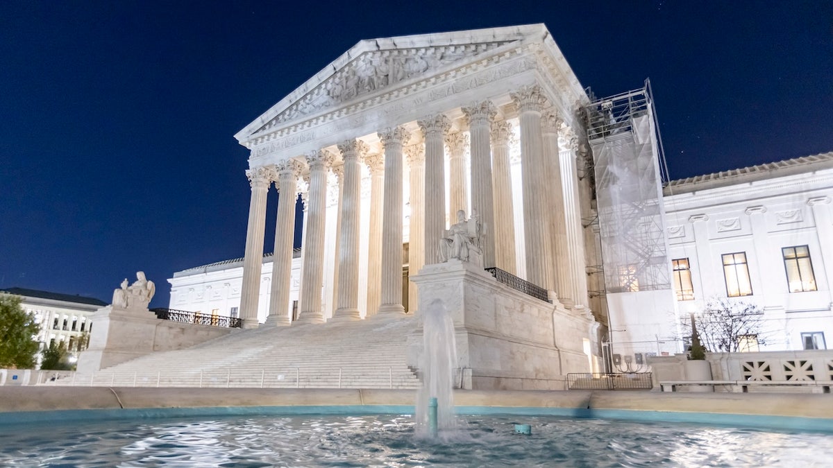 Supreme Court of the United States building illuminated at night with water fountain in front