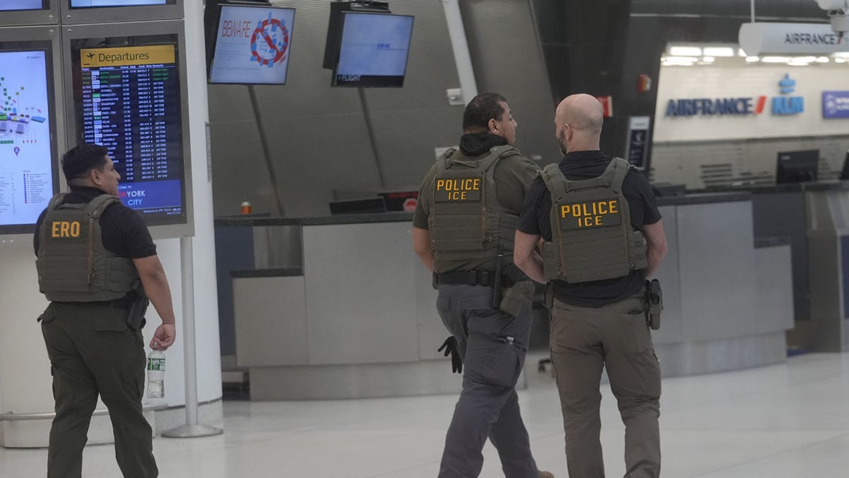 U.S. Immigration and Customs Enforcement agents standing inside Terminal 1 at JFK Airport