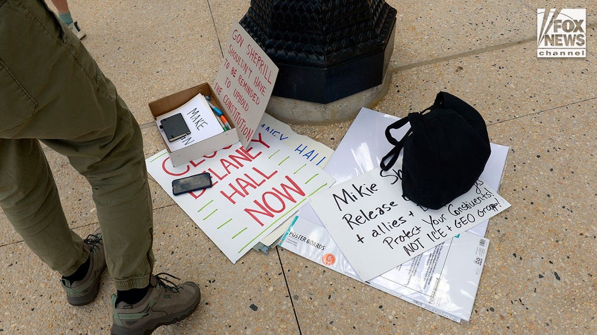 Protestors outside Mikie Sherrill's office holding signs and petitions in Trenton