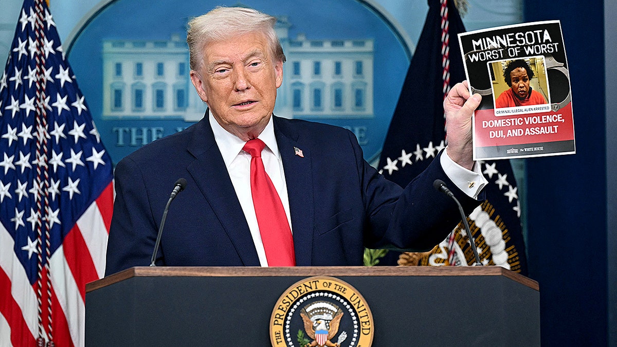 President Donald Trump holding up an image of a criminal illegal alien