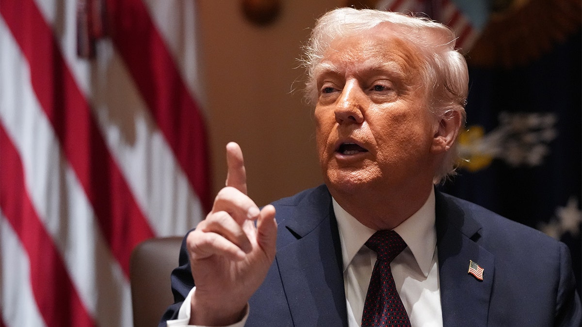 Donald Trump speaking at a podium with an American flag in the background