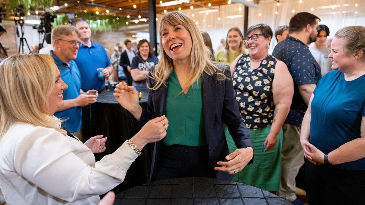 Sarah Trone Garriott smiles as she talks with a crowd
