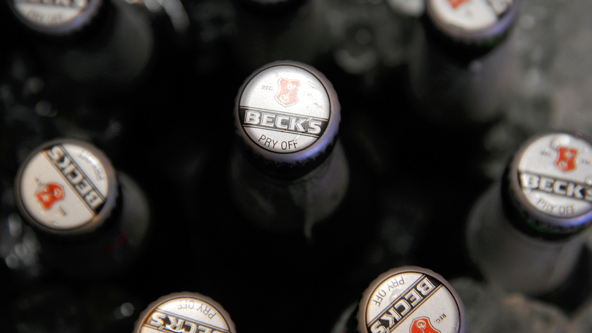 The tops of Beck's beer bottles are seen in an ice chest.