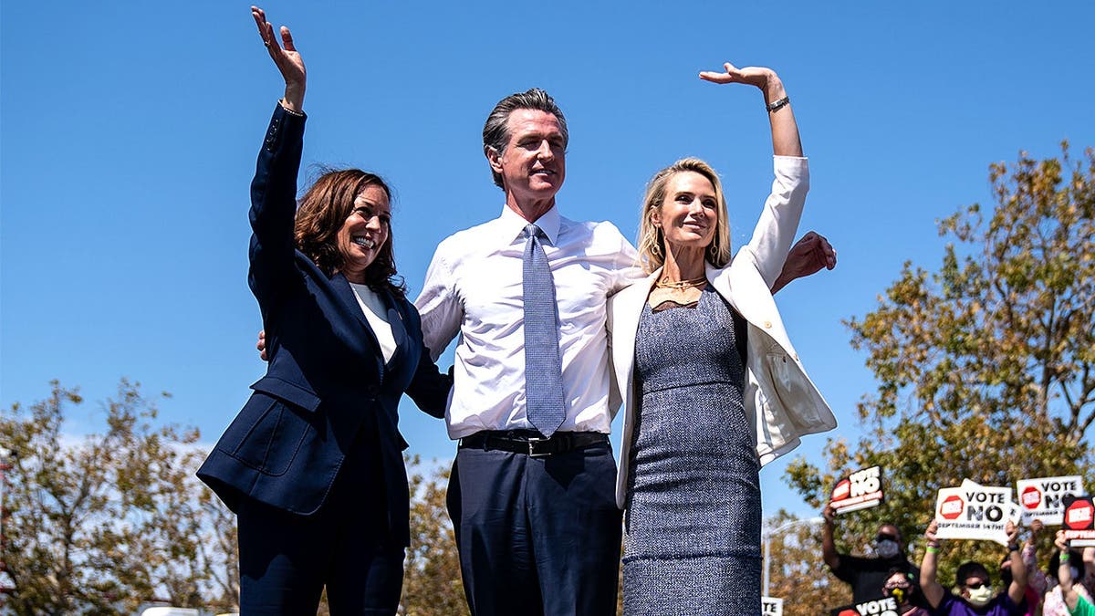 Kamala Harris and Gavin Newsom wave at California campaign rally.