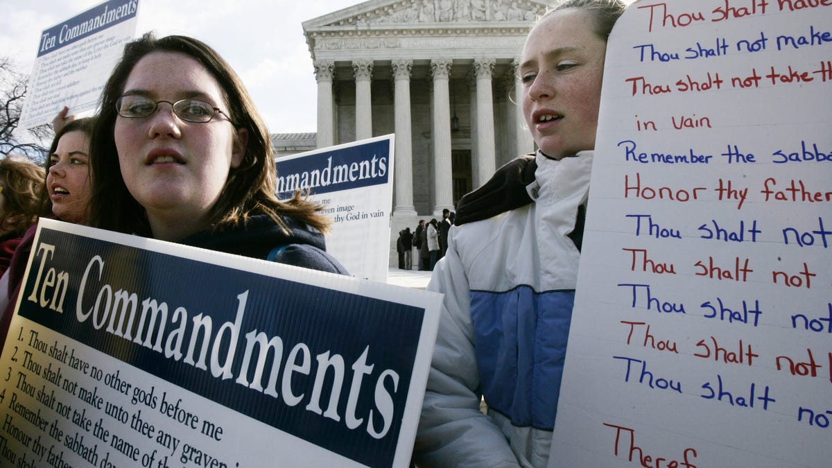 WASHINGTON - MARCH 2: Anna Dollar (2nd L) of Boone, NC, and Deanna Gosnell (R) of Avery, North Carolina, hold posters during a rally in front of the U.S. Supreme Court to support the Ten Commandments March 2, 2005 in Washington, DC. The Supreme Court heard two cases on whether Ten Commandments monuments should be displayed on government properties. (Photo by Alex Wong/Getty Images)