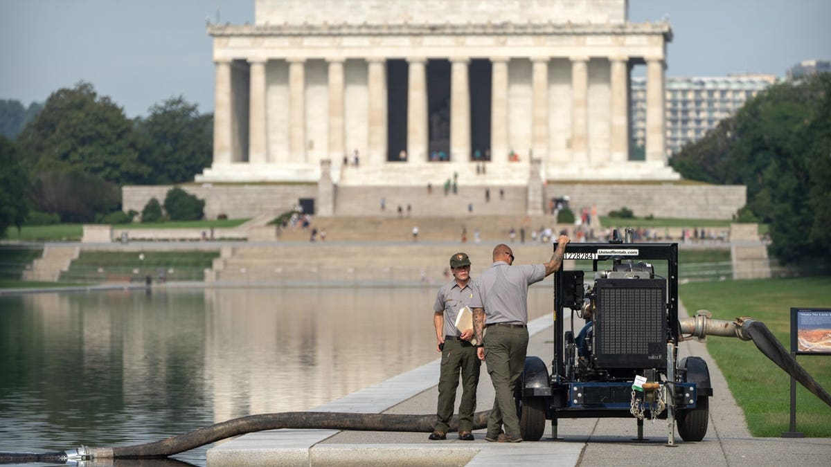 National Park Service workers stand near a pump placed next to the Lincoln Memorial Reflecting Pool