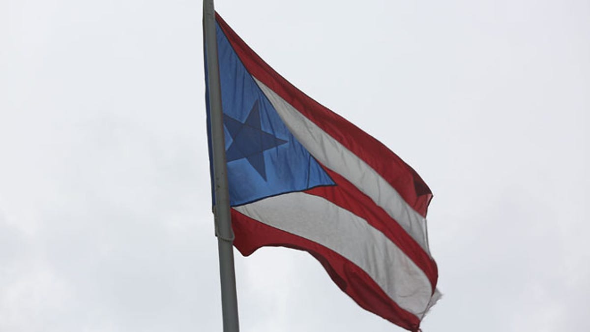 SAN JUAN, PUERTO RICO - JULY 01: The Puerto Rican flag flies near the Capitol building as the island's residents deal with the government's $72 billion debt on July 1, 2015 in San Juan, Puerto Rico. Governor of Puerto Rico Alejandro GarcÃ­a Padilla said in a speech recently that the people of Puerto Rico will have to make sacrifices and share the responsibilities to help pull the island out of debt. (Photo by Joe Raedle/Getty Images)