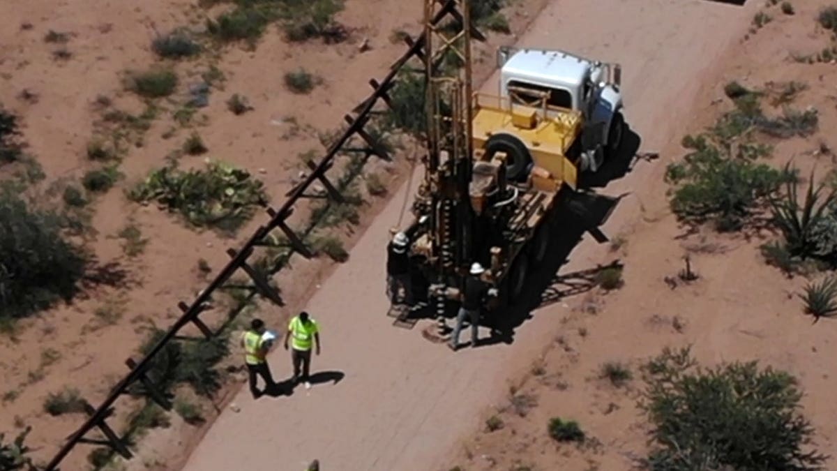 Contractors drill at a border wall pre-construction site in Arizona.