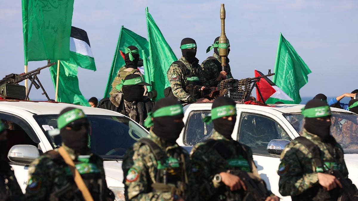 Keith Siegel, an Israeli-American hostage, is handed over by Hamas fighters to a Red Cross team on a Gaza beachfront.