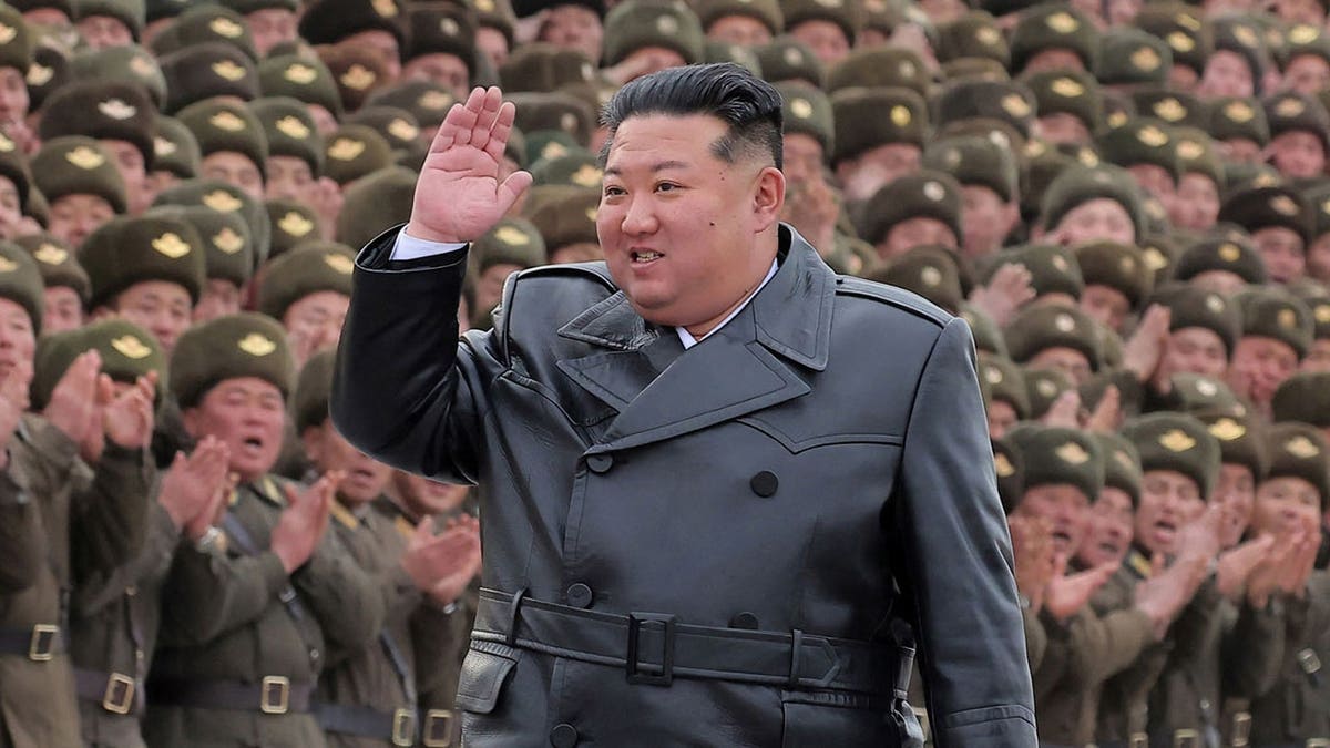 Kim Jong Un stands with soldiers during a commemorative photo session.