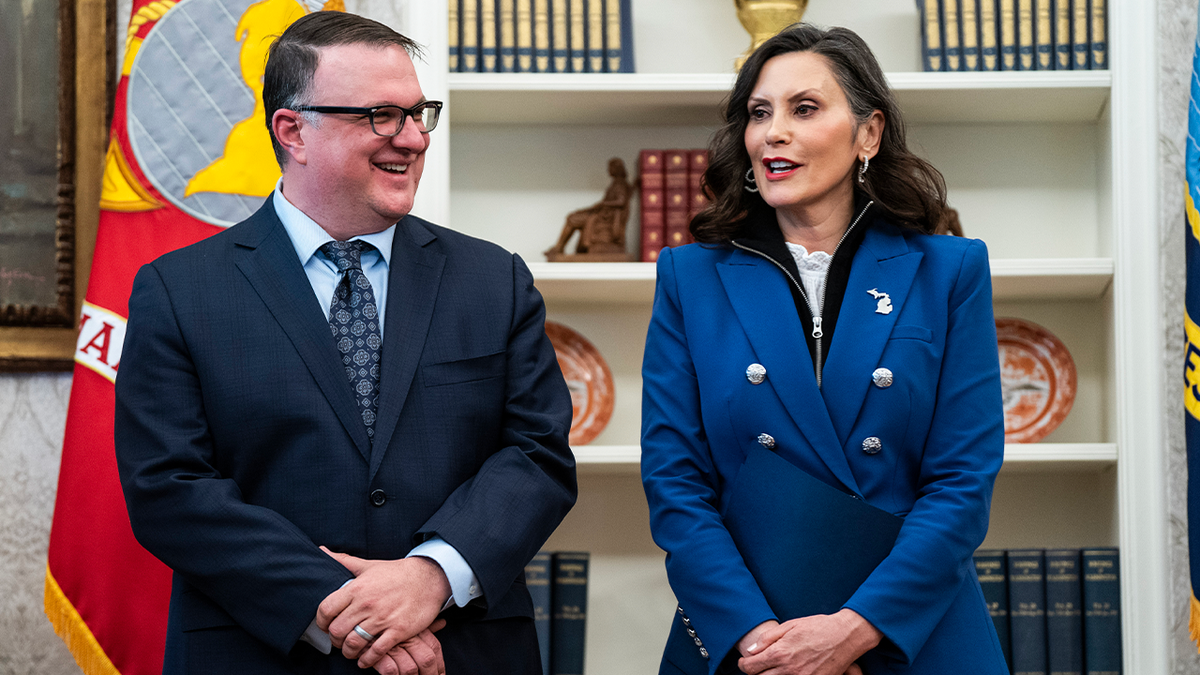 Michigan House Speaker Matt Hall stands with Gov. Gretchen Whitmer during an event