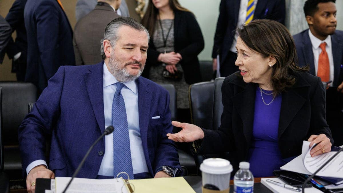 U.S. Sen. Ted Cruz talks to Sen. Maria Cantwell before a Senate committee hearing in Washington, D.C.