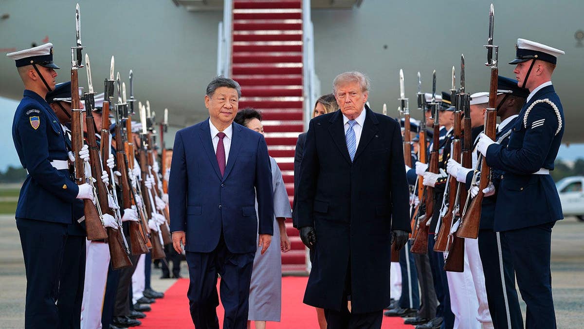 President Donald Trump walks on a red carpet after greeting Chinese President Xi Jinping at Joint Base Andrews.