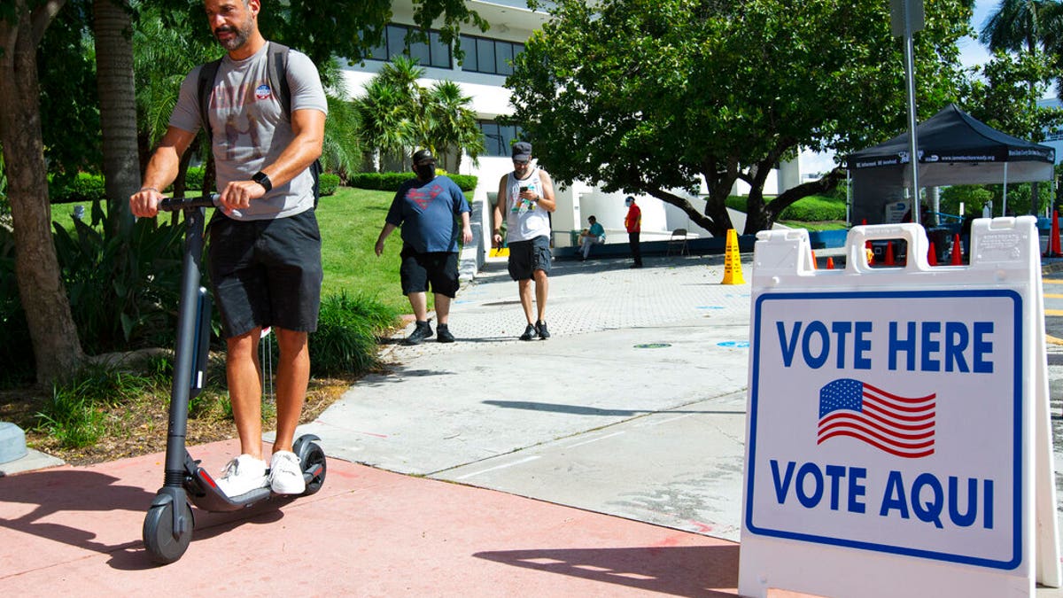 People leave after casting their vote during early voting in Miami Beach, Fla.
