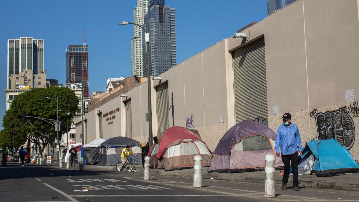 Tents are lined up on the sidewalk in front of the non-profit Midnight Mission's headquarters, while traditional Thanksgiving meals are served to nearly 2000 homeless people in the Skid Row neighborhood of downtown Los Angeles on November 25, 2021. (Photo by Apu GOMES / AFP) (Photo by APU GOMES/AFP via Getty Images)