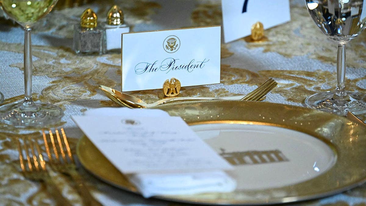Donald Trump sits at a table during a dinner with donors in the White House East Room.