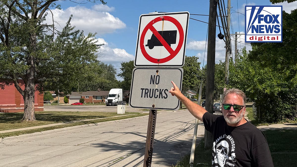 A man pointing at a sign