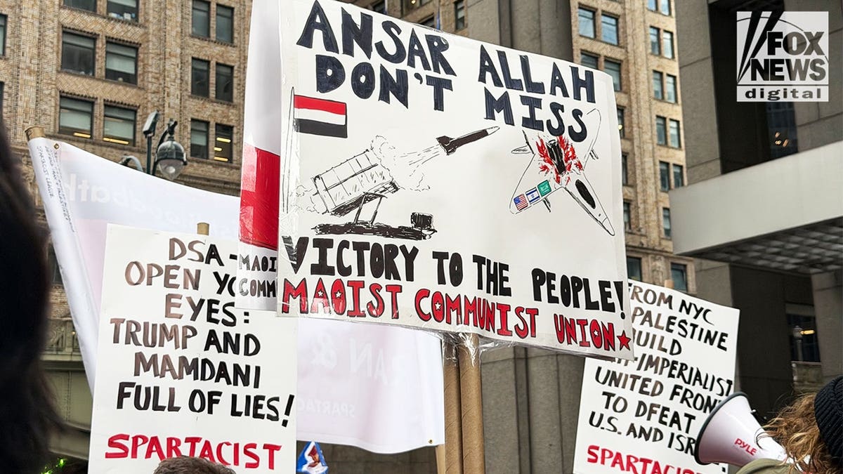Maoist Communist Union and Spartacist League signs displayed at an anti-Israel protest in New York City.