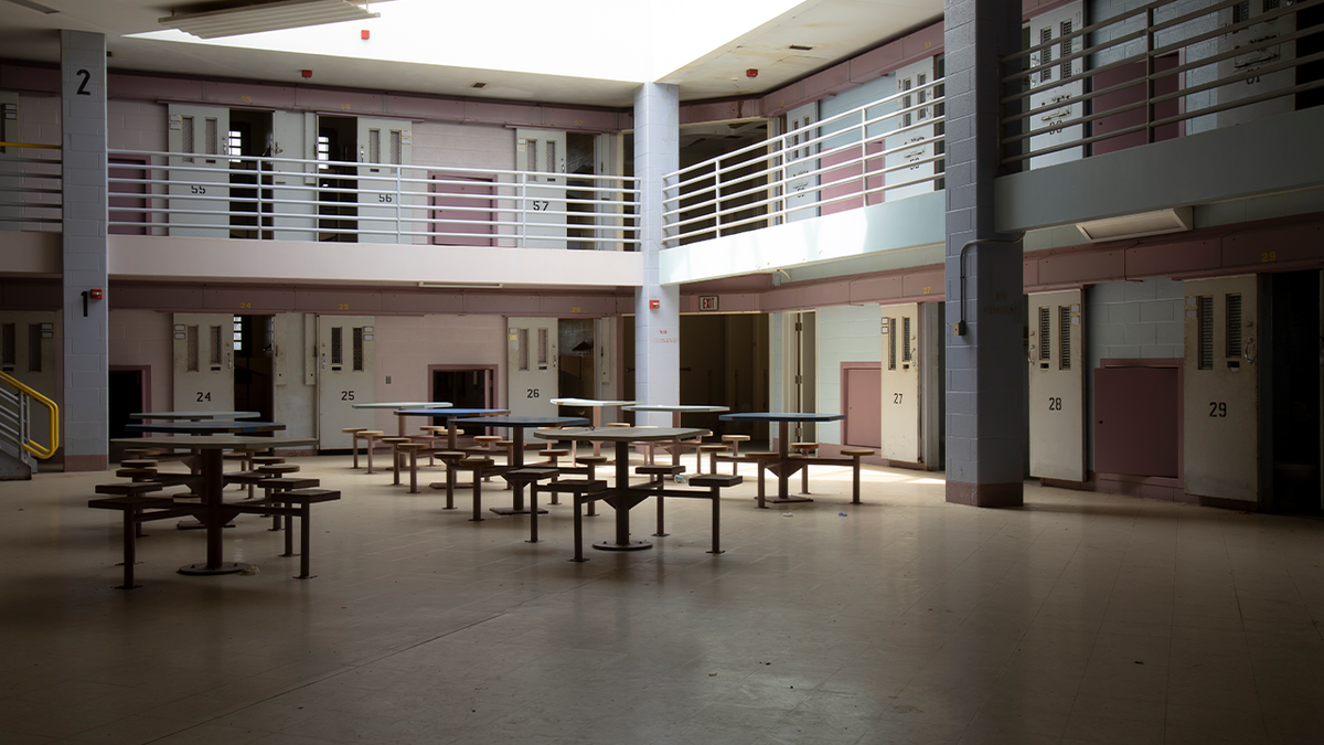 empty common area in state jail, with two levels of cells visible