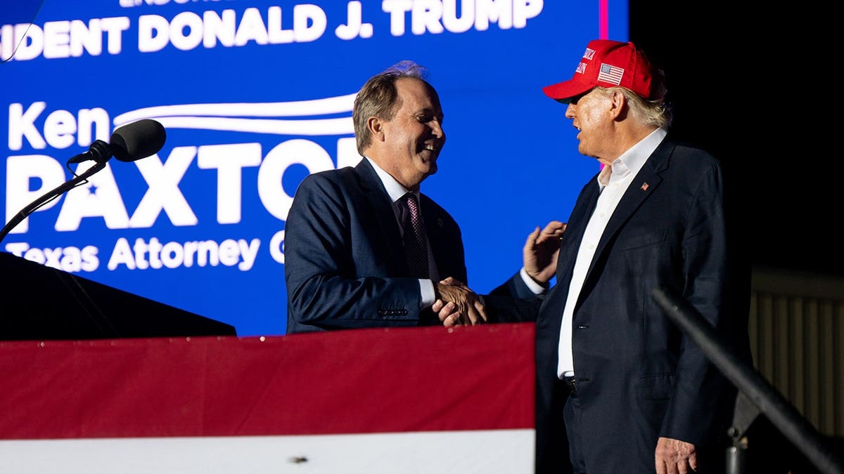 Texas Attorney General Ken Paxton greets former President Donald Trump at a rally.