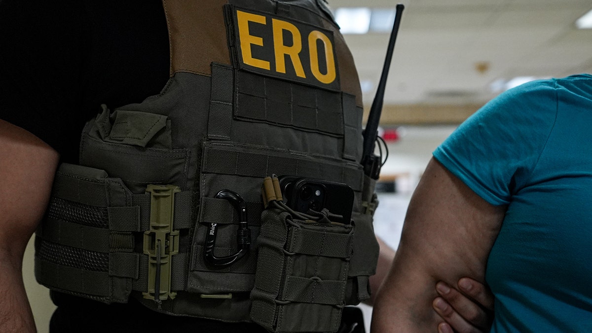 ERO agent holding an illegal immigrant's arm