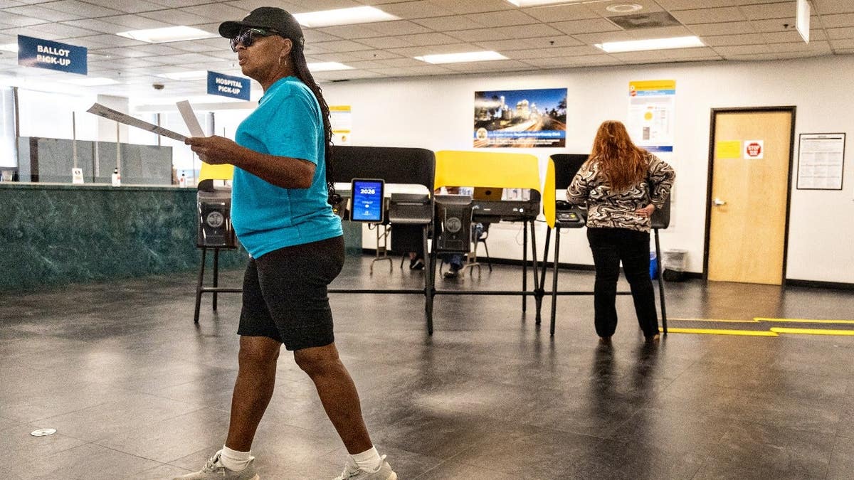Multiple people vote early at the Los Angeles County Registrar-Recorder's office.