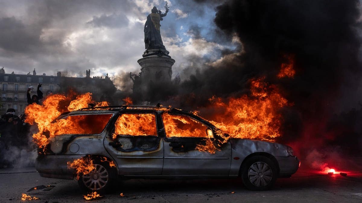 A car is set ablaze during demonstrations in Paris, France.
